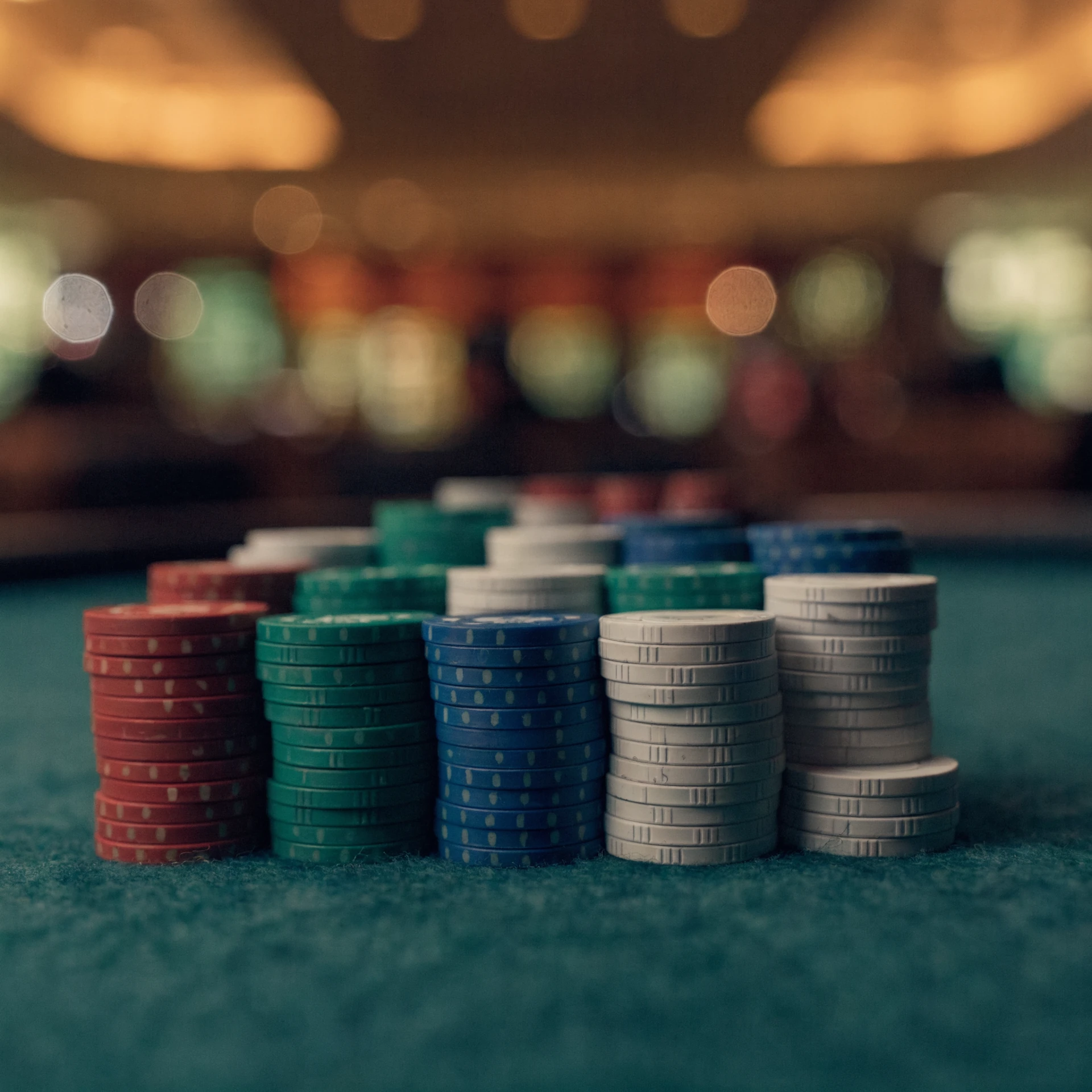Små casinochips i staplar — låg-budget casinospel kräver inte stora insatser